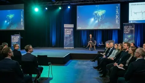 Still from The Sea Candle: the Reykjavik summit stage and audience in blue light